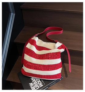 Détail du sac cabas tricoté à rayures rouges et blanches avec bandoulière en cuir réglable