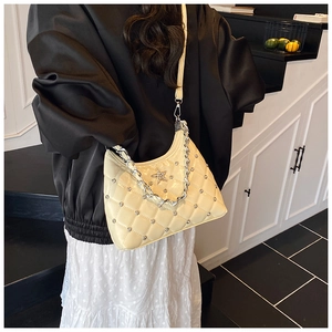 Détail du sac à bandoulière matelassé beige clair avec emblème étoile et chaîne argent