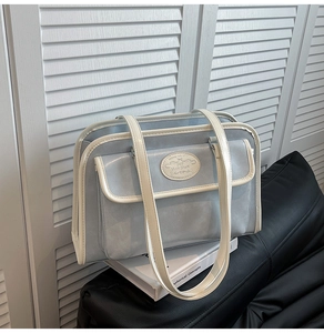 Gros plan sur un sac vintage bleu clair avec liseré blanc et détail logo métallique