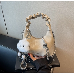 Détail du sac à main plissé crème avec chaîne argentée et breloque nuage doux