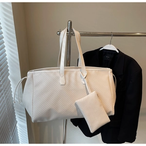 Détail de la texture tissée du sac cabas crème minimaliste avec pochette assortie