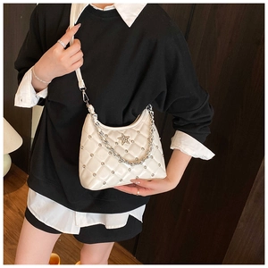 Détail du sac bandoulière blanc en cuir matelassé avec rivets étoile et chaîne