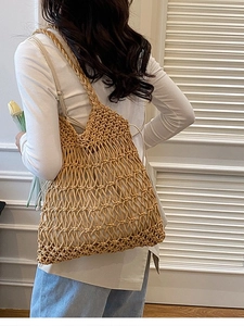 Boho style hollow out woven shoulder bag with floral accents for beach vacations