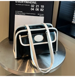 Détail d'un sac cabas bicolore noir et blanc minimaliste avec de fines doubles bretelles
