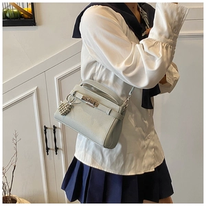 Close-up of light blue leather handbag with silver twist lock and ball charm detail