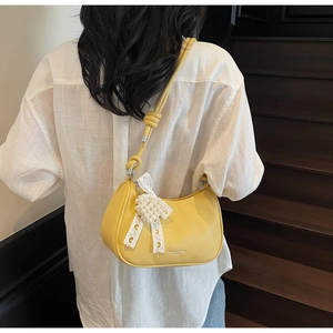 Vista dettagliata della borsa hobo gialla con texture lychee e ciondolo con fiocco