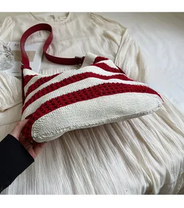 Détail du sac fourre-tout en tricot rayé rouge et blanc avec bandoulière en similicuir rouge