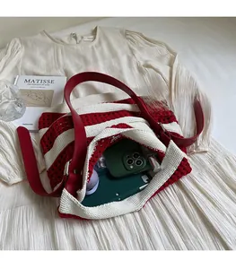 Détail du grand sac cabas en tricot rayé rouge et blanc avec bandoulière en cuir rouge