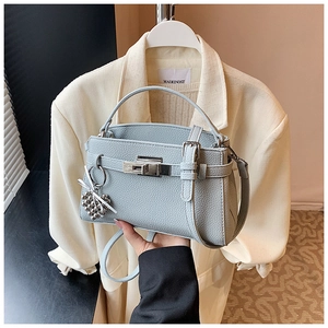 Detail of light blue pebble leather handbag with silver twist lock and bead charm