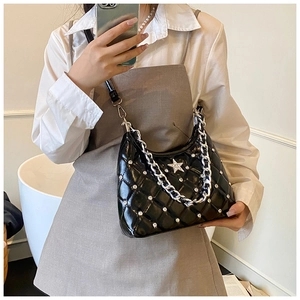 Détail du sac bandoulière noir matelassé avec étoile en strass et chaîne argentée