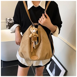 Detail of khaki suede hobo bag with brown leather strap and cute bear charm pendant