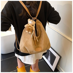 Rear view of a large brown suede tote bag featuring a cute fashion plush bear charm