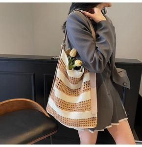 Detail of woven tote bag with brown and white stripes and leather shoulder strap