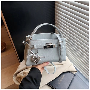 Detail of light blue lychee pattern leather handbag with silver lock and heart charm