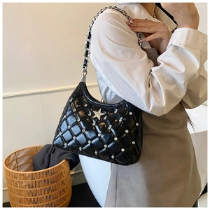 Détail du sac matelassé noir avec badge étoile argentée et ornements en strass