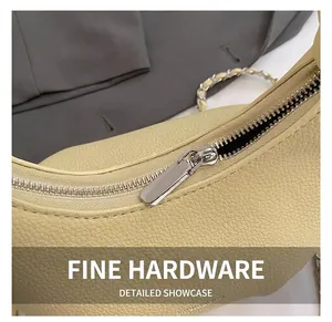 Close-up of silver metal zipper and beige lychee pattern leather texture on bag
