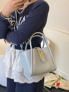 Light blue crocodile pattern bucket bag with golden twist lock and top handles