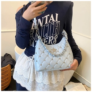 Détail du sac bandoulière bleu clair matelassé avec rivets étoile et chaîne argentée