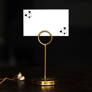 Elegant gold heart table number holder with a round base for wedding seat cards