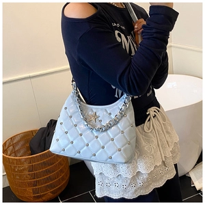 Détail du sac matelassé bleu clair avec boucle étoile et bandoulière chaîne