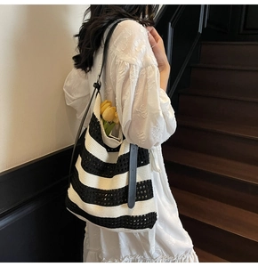 Détail du sac cabas en maille rayée noir et blanc avec texture ajourée et lanières