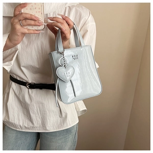 Detail of light blue patent leather handbag with heart charm and Fan Tor logo