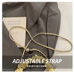 Detail showing pale yellow leather and silver chain adjustable strap with metal slider