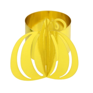 Macro detail of a golden pumpkin napkin ring with intricate hollow metal design for Halloween