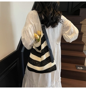 Detail of black and white striped crochet tote bag with adjustable leather strap