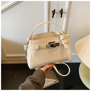 Detail of off-white lychee texture leather handbag with gold metal rotary lock buckle