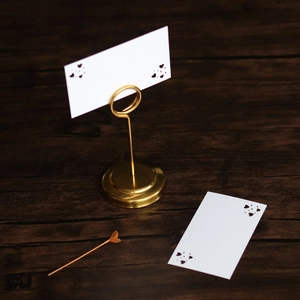 Detailed view of a gold heart-shaped place card holder with elegant white name cards