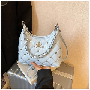 Détail du sac matelassé bleu clair avec emblème étoile argenté et chaîne métal
