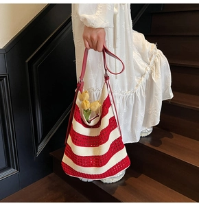 Close-up of red and white striped crochet tote bag with red leather strap and tulip decor