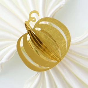 Close-up of golden pumpkin napkin ring with hollowed-out vine details for festive tables