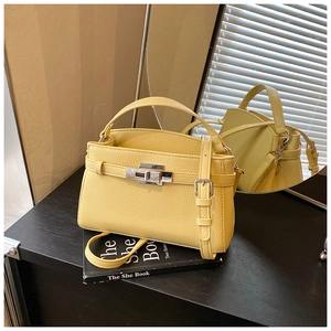 Detailed view of yellow litchi grain leather Kelly bag with silver hardware and lock