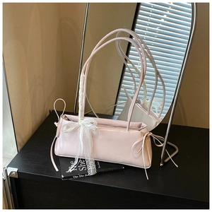 Detail view of pink glossy handbag with lace bow decoration and stylish side ribbons