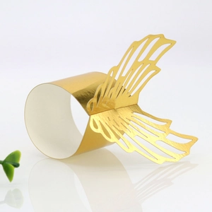 Detail of laser-cut gold butterfly napkin ring with intricate lace texture pattern