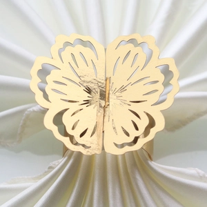 Detailed view of elegant gold floral napkin ring on a white folded cloth