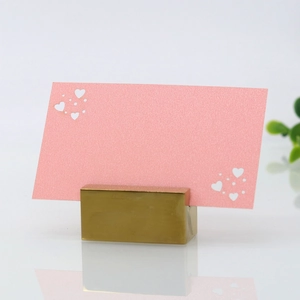 Gold table number holder with a pink laser-cut heart card for wedding seating