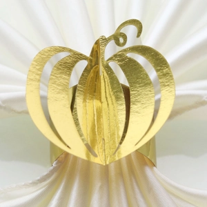 Detail of a golden pumpkin napkin ring featuring an elegant hollow-out festive design