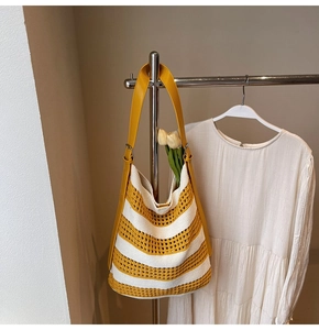Détail du sac cabas au crochet rayé jaune et beige avec bandoulière en cuir sur cintre