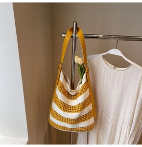 Detail of yellow and white striped crochet tote bag with adjustable leather shoulder strap