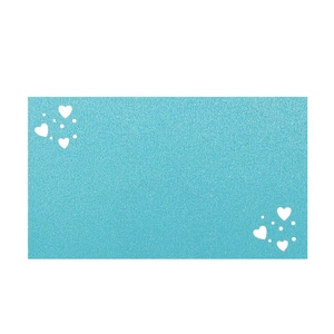 Detail of light blue glitter place card with white heart and dot decorative patterns