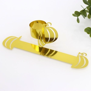 Detail of glossy gold pumpkin paper napkin rings for Halloween table decor setting
