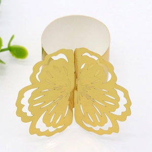 Close-up of golden hollow butterfly napkin ring with detailed laser-cut wing patterns