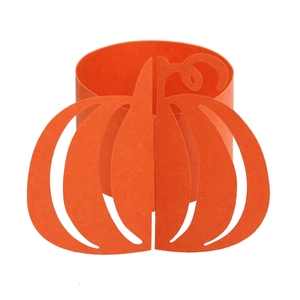 Macro shot of orange pumpkin paper napkin ring with laser-cut details for Halloween