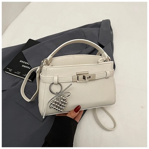 Detail of white litchi leather trapezoid handbag with silver buckle and grape bead charm