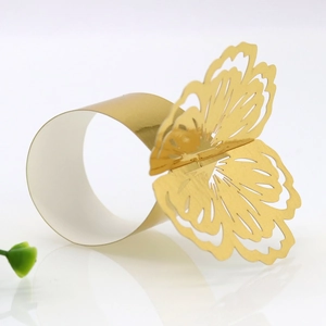 Detailed view of hollowed-out butterfly napkin ring in shiny gold finish for weddings