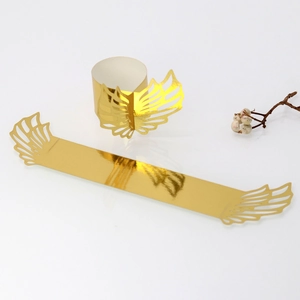 Macro detail of gold hollow angel wing napkin ring with elegant metallic texture