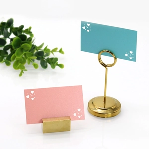 Close-up of elegant gold metal heart card holders for wedding table numbering